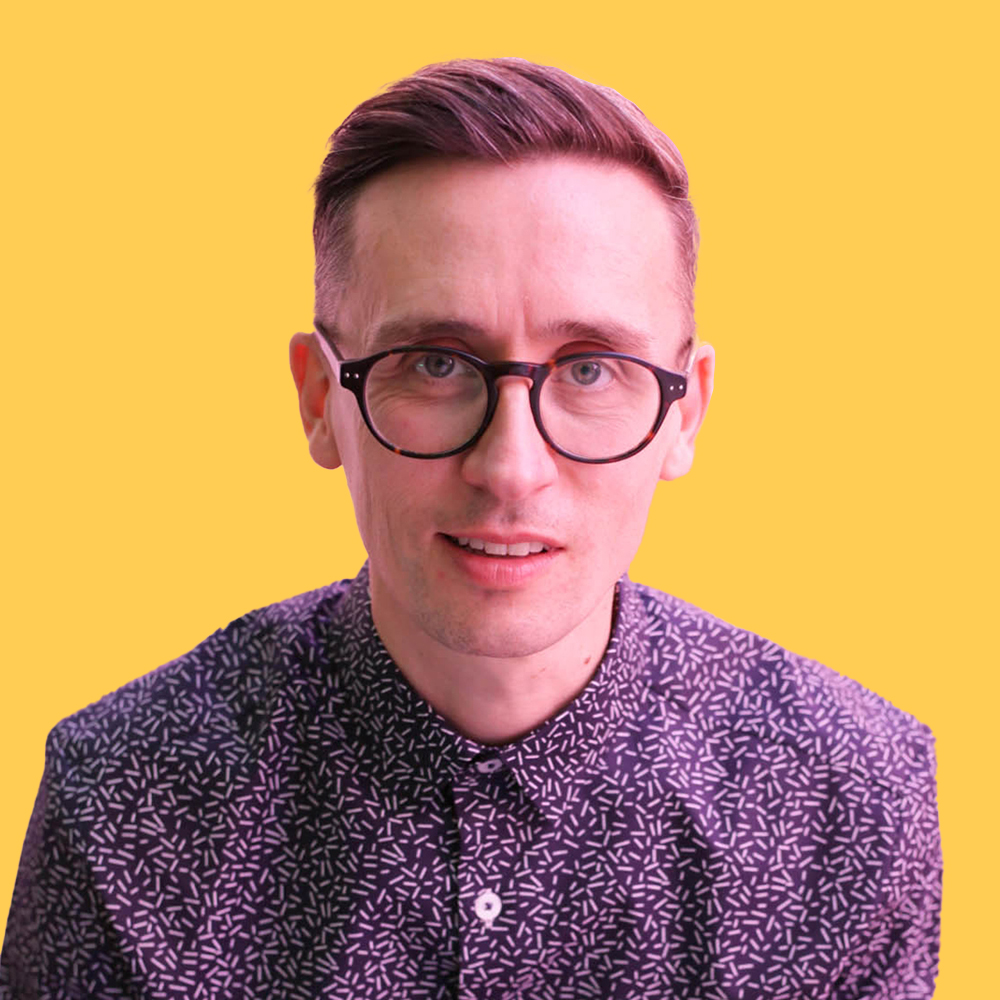 Professional headshot of a marketing agency owner in Nottingham, captured with a vibrant yellow background to enhance personal branding.